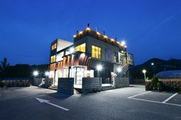 조명이 켜진 밤의 펜션 건물과 주차장
