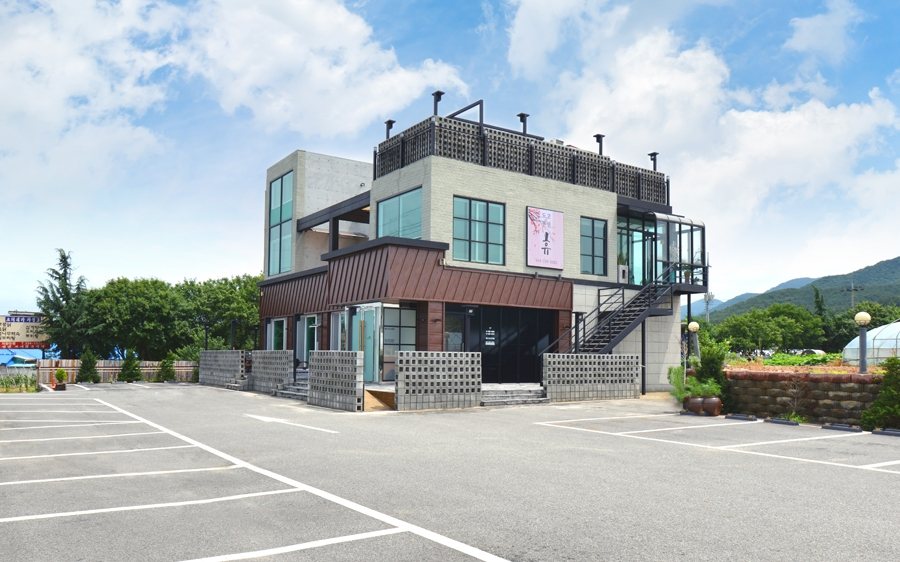 맑은 날 건물 정면과 주차장